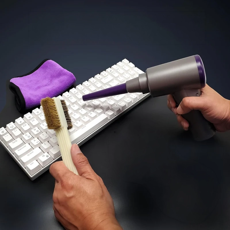 Cyberguys! desk cleaning tools being used on a keyboard