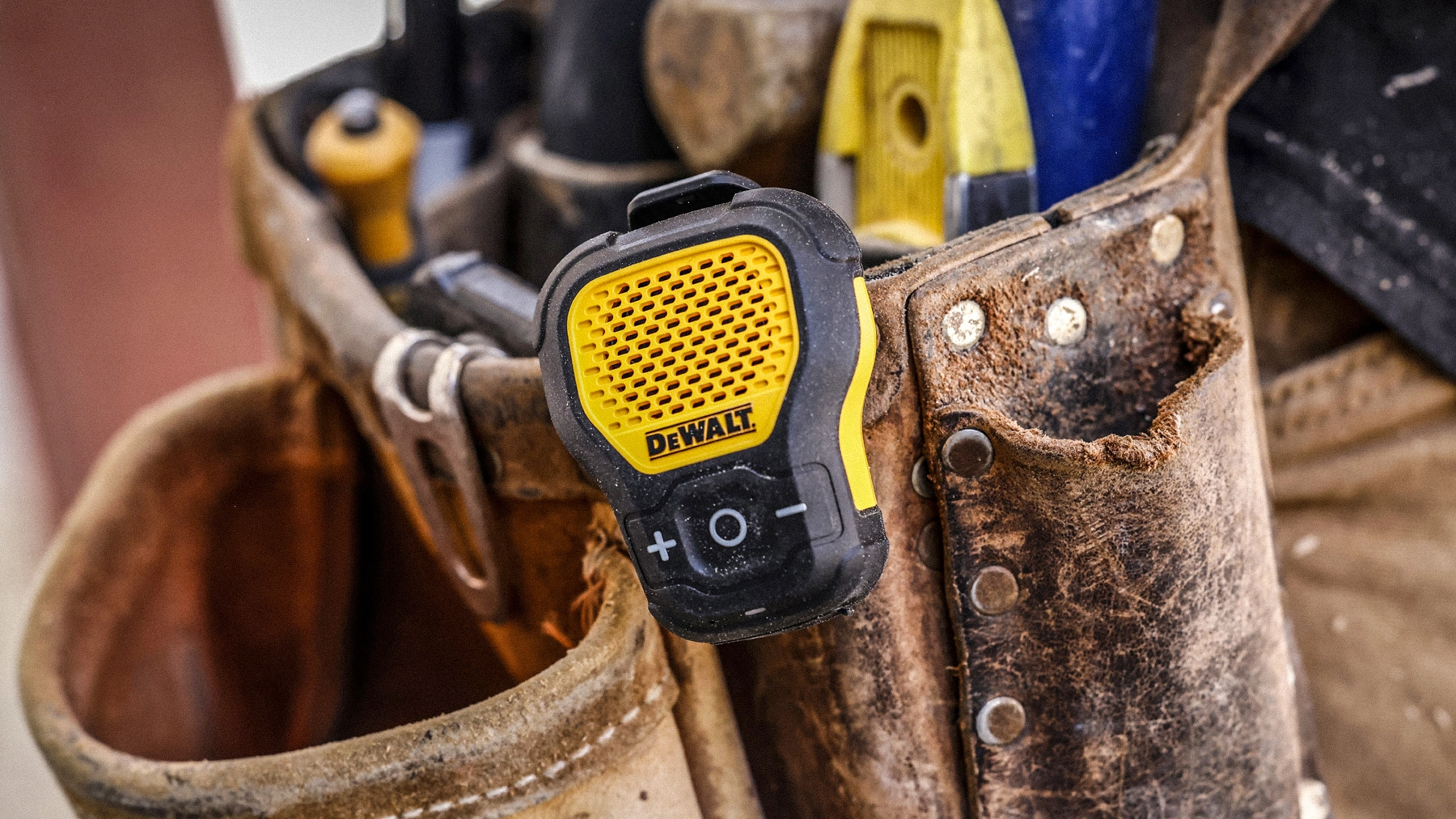 DEWALT wearable speaker clipped to a jobsite tool belt