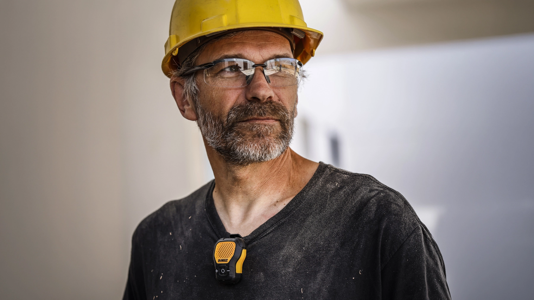 Worker wearing the DEWALT wearable speaker on a shirt collar